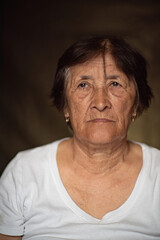 Portrait of an elderly woman in the studio close-up on a dark background.
