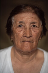 Portrait of an elderly woman in the studio close-up on a dark background.