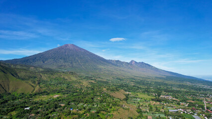 Fototapeta premium Aerial view of some agricultural fields in Sembalun. Sembalun is situated on the slope of mount Rinjani and is surrounded by beautiful green mountains. Lombok, Indonesia, March 22, 2022