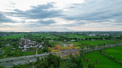Fototapeta na wymiar Aerial view of the city colorful Monument Tembolak Rainbow on Mataram. The newest icon from the city of Mataram Indonesia. Lombok, Indonesia, March 22, 2022