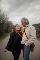 A couple, man and woman, 60 and 70 years old, with gray hair, look into each other's eyes during a romantic walk in spring, in a rural area of the province of Zaragoza, Aragon, Spain