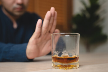 Drunk men deny drinking more glass of whisky by pushing away.