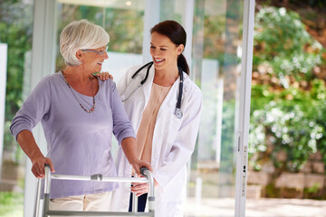 Obraz premium Checking up on the daily progress. Shot of a senior woman using an orthopedic walker, chatting happily with her doctor.