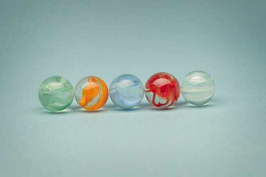 Five different coloured marbles representeing their difference but that they are also the same