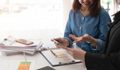 Two beautiful business people working together using a tablet at a modern office.