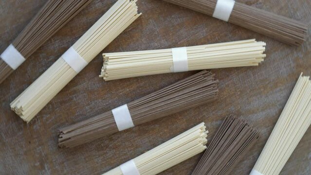 Soba noodle and ramen noodle. Two types of traditional Chinese noodle product: wheat and buckwheat ingredient. Table spin.