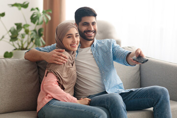 Contented Middle Eastern Spouses Watching Movie On TV At Home