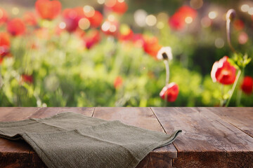 wooden rustic table in front of field red poppies. product display and picnic concept