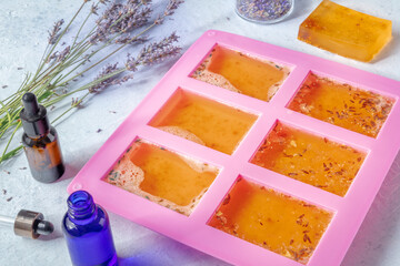 Soap making. Liquid glycerin with natural additives in a silicone mould, with essential oils and...