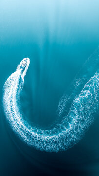 Vertical Top View Of A Boat Making Beautiful Trails