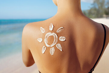 Skin care. Sun protection. Woman apply sun cream. Woman With Suntan Lotion On Beach In Form Of The...