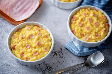 Cheesy millet with ham slices in a baking bowl