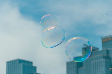 Closeup of soap bubbles floating in the air against the background of buildings