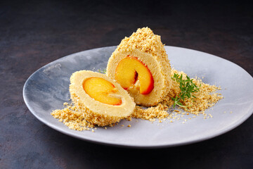 Traditioneller österreichischer Marillenknödel mit einer Marille im Teigmantel und Butterstreuseln serviert als close-up in einer Nordic Design Schale 