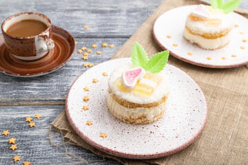Decorated cake with milk and coconut cream with cup of coffee on a gray wooden background. Side view.