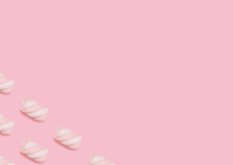 Marshmallow. Top view photo in minimal style. Swirl two-tone candies on pastel pink background