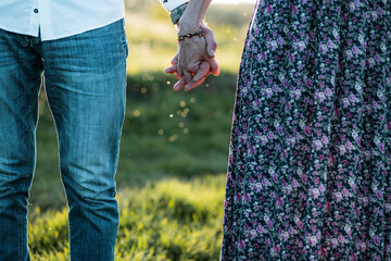 couple walking in nature at sunset holding hands