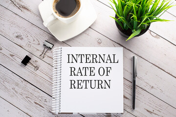 Cofee cup, notepad,pen on the wooden background. Business concept. Text Internal Rate of Return IRR