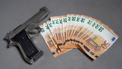 Money cash banknote  50 Euro and revolver gun army - order a murder, criminal underworld and social...
