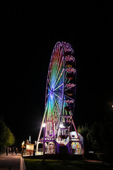 Vertical shot of illuminated Ferris wheel on the German island of Usedom at night - obrazy, fototapety, plakaty