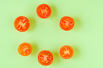 Fototapeta premium Cut tomatoes on green background