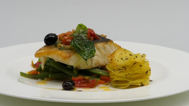 Trancio di pesce alla griglia, servito con patate.
Piatto con verdura, patate e trancio di pesce alla griglia.