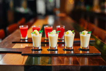 Sweet alcohol liqueur cocktail shots on the wooden table