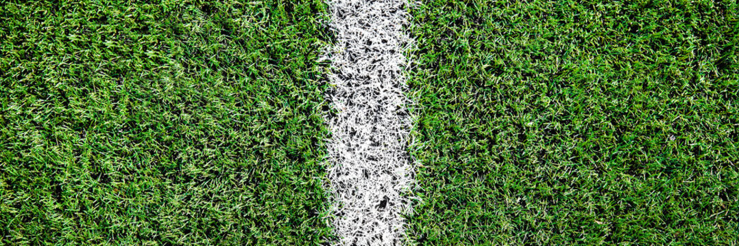 Part of football or soccer field close up, Artifical green grass with white border lines, Astroturf at stadium for spart games