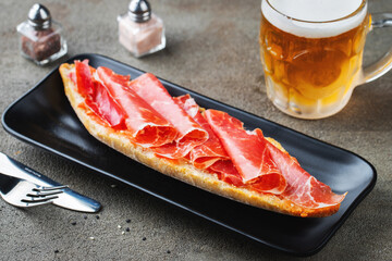 Traditional Spanish breakfast. Tostada with different toppings on a dark background