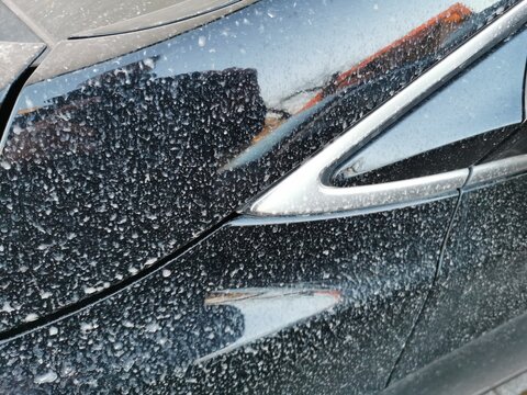 Saharasand auf schwarzem Auto nach dem Regen