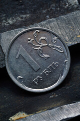 Russian coin denominated 1 ruble. shines on a scratched metal surface. close-up. translation of the text on the coin "1 ruble"