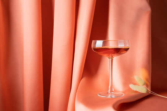 Glass of alcoholic drink on red fabric
