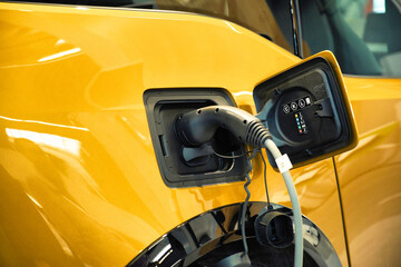 Closeup shot of the electric yellow car charging