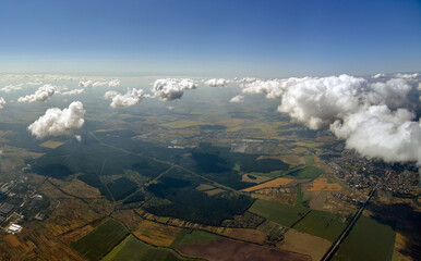 Aerial view from airplane window at high altitude of earth covered with white puffy cumulus clouds
