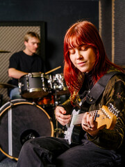 Obraz na płótnie Canvas Young guitarist and drummer in a music studio