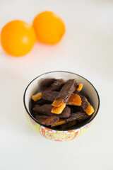 Small ceramic bowl of candied orange peel dipped in dark chocolate