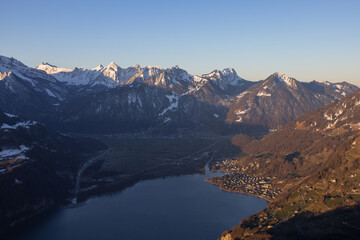 Great view on a beautiful morning over a lake called Walensee. The mountains in the background are illuminated by the morning sun.