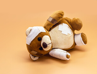 torn children's toy with bandages and bandages, concept of childhood violence or child aggression