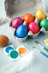 Bunte Ostereier im Karton mit Pinsel und Farben