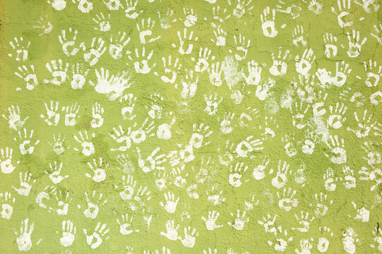 Concept of solidarity, diversity, peace, no war, participation, support, brotherhood, hope. White hands on a background green wall 