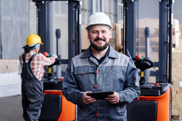 Successful mature male picker or quality control manager with tablet standing in front of camera...