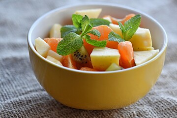fruit salad of tangerines kiwi apples pomegranate seeds. healthy eating
