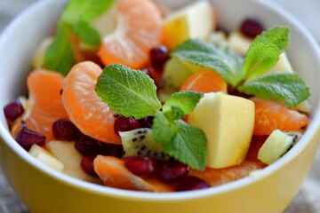 fruit salad of tangerines kiwi apples pomegranate seeds. healthy eating