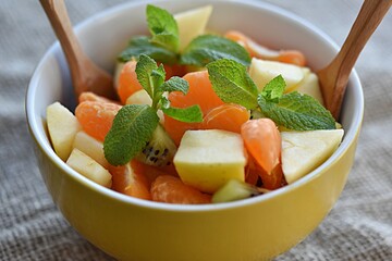 fruit salad of tangerines kiwi apples pomegranate seeds. healthy eating