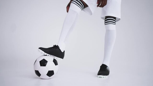 junior footballer is pulling his knee socks of sport uniform of professional soccer team