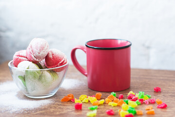 Multicolored cookies in the form of Nuts with filled cream, candied fruit and strainer and cup of coffee on light back