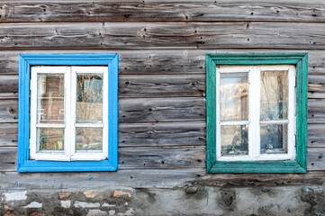 Old wooden windows on the background of a wall made of old wooden beams.