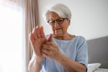 Senior woman with arthritis rubbing hands
