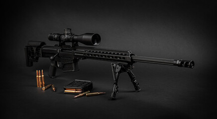 Modern powerful sniper rifle with a telescopic sight mounted on a bipod. Ammo and an additional magazine next to the rifle. - obrazy, fototapety, plakaty