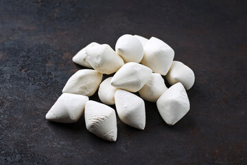 Traditionelle afghanische getrocknete Quark Kaschk Stücke als close-up auf schwarzem rustikalem Hintergrund mit Textfreiraum